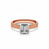 Ring with a emerald cut diamond on a rose gold band.