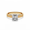 Ring with a emerald cut diamond on a yellow gold band.